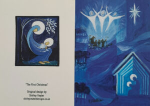 Illustrated in blues; The Angela visit the shepherds on the hillside and in the foreground in a stable we see Mary cradling the new baby Jesus. On the back of the card is a small Mother & Child image.